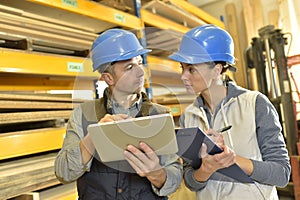 Worker talking to overseer in warehouse