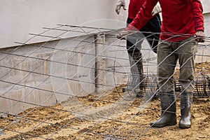 Worker team work install wire mesh on sand floor for reinforce concrete before fill liquid cement on road