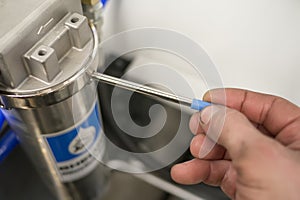 Worker tighten industrial water filter by hand