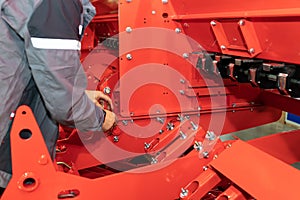 Worker tighten nut. Assembly stage of agricultural machine