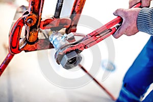 Worker tightening pipes at plumbing installation