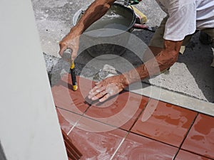 Worker tiler metre laying tiles intent in his work photo