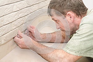 Worker tiler at wall decoration photo