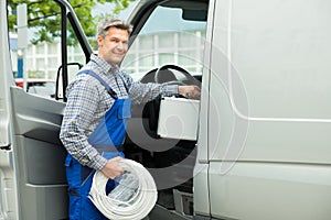 Worker With Toolbox And Cable Entering In Van