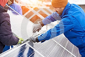 Worker with tools maintaining photovoltaic panels. Engineers installing solar panels