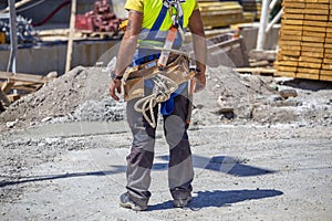 Worker with tools in toolbelt and construction tools