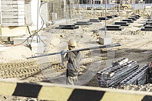 A worker transfers elements for the installation of the formwork at the construction site. Monolithic concrete formwork during the