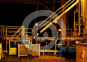 The worker transfers at night time from a boat of offshore marine service to oil and gas