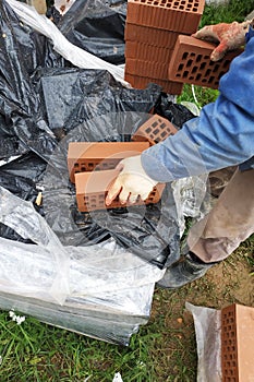 The worker translates the facade bricks for further measurement and trimming for construction