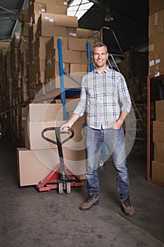 Worker with trolley of boxes in warehouse