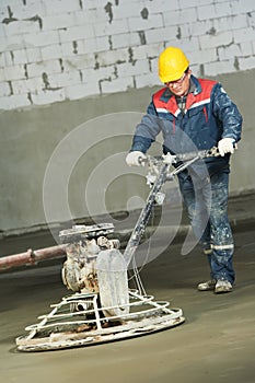 Worker trowelling and finishing of concrete photo