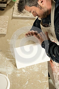 Worker Trying to Detach a Plaster Model from Mold