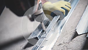 Worker twists the screw into the metal