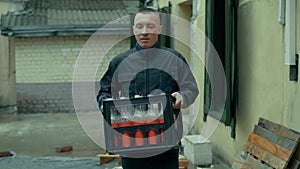 A worker in uniform is carrying cargoto the warehouse.Loader man is deliver the goods.Warehouse worker is holding heavy