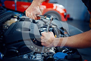 Worker disassembles vehicle engine, car service photo