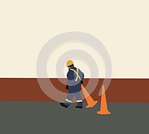 Worker with uniform and safety equipment move traffic cone for road construction.