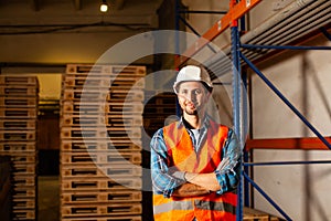 The worker in uniform is standing near the shelves