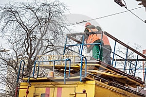 Worker in uniform on top electrical service truck