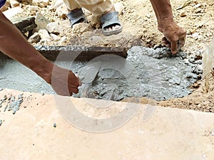 Worker use trowel to equalize cement