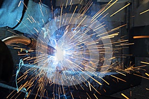 A worker use a welding machine to weld a piece of metal.