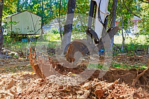 Worker uses an excavator to uproot trees as part of preparation ground