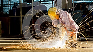 worker uses grinding cut metal, focus on flash light line of sharp spark,in low light