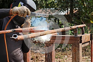 A worker uses tools to weld steel