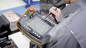 Worker uses touch control panel. Scene. Skilled worker uses electronic control panel in modern enterprise. Close-up of