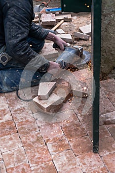 A building worker is operating an angle grinder on a metal door producing sparkles photo