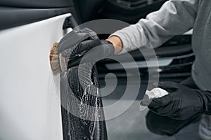 Worker using automotive soap and brush for carwash