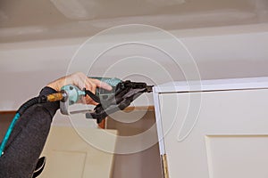 Worker using brad nail gun installs doors
