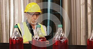 Worker using digital tablet in bottle factory