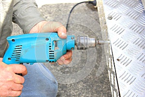 Worker using electric drill