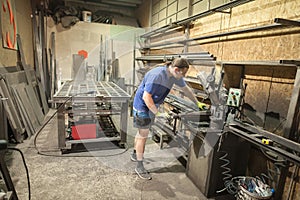 Worker using electric wheel grinding on steel structure in factory