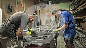 Worker using electric wheel grinding on steel structure in factory