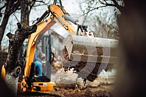 Worker using excavator and bulldozer for landscaping works