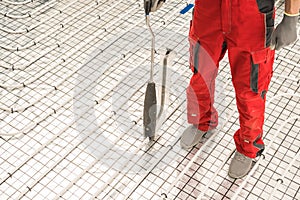 Worker Using Floor Radiant Heating Pipeline Foam Board Stapler