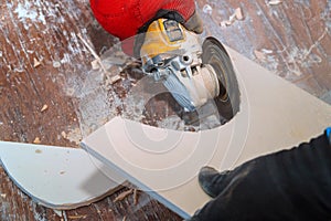 Worker using an grinder cutting a floor tile