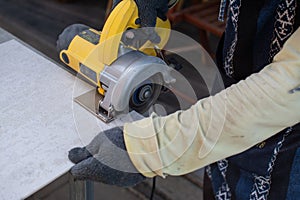 Worker using a grinding machine for cut cement board