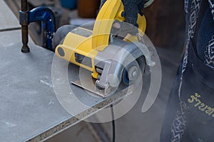 Worker using a grinding machine for cut cement board