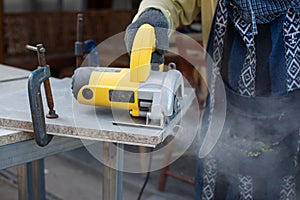 Worker using a grinding machine for cut cement board