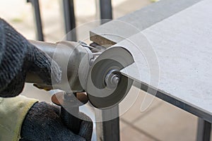 Worker using a grinding machine for cut cement board