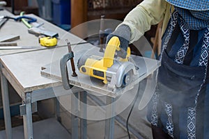 Worker using a grinding machine for cut cement board