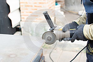 Worker using a grinding machine for cut cement board