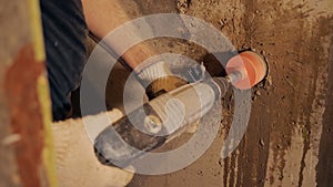 Worker using hammer drill on site