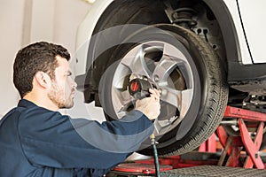 Worker Using Impact Wrench On Change Tire