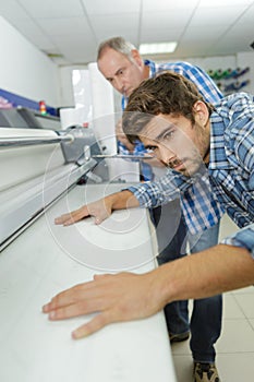 Worker using large format ink jet printer