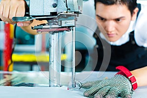 Worker using a machine in chinese factory