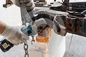 Worker using a metal grinder machine to cut off a piece of metal