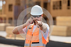 Worker using phone, builder taking on phone a break from work. Architect with mobile phone. Portrait worker man with